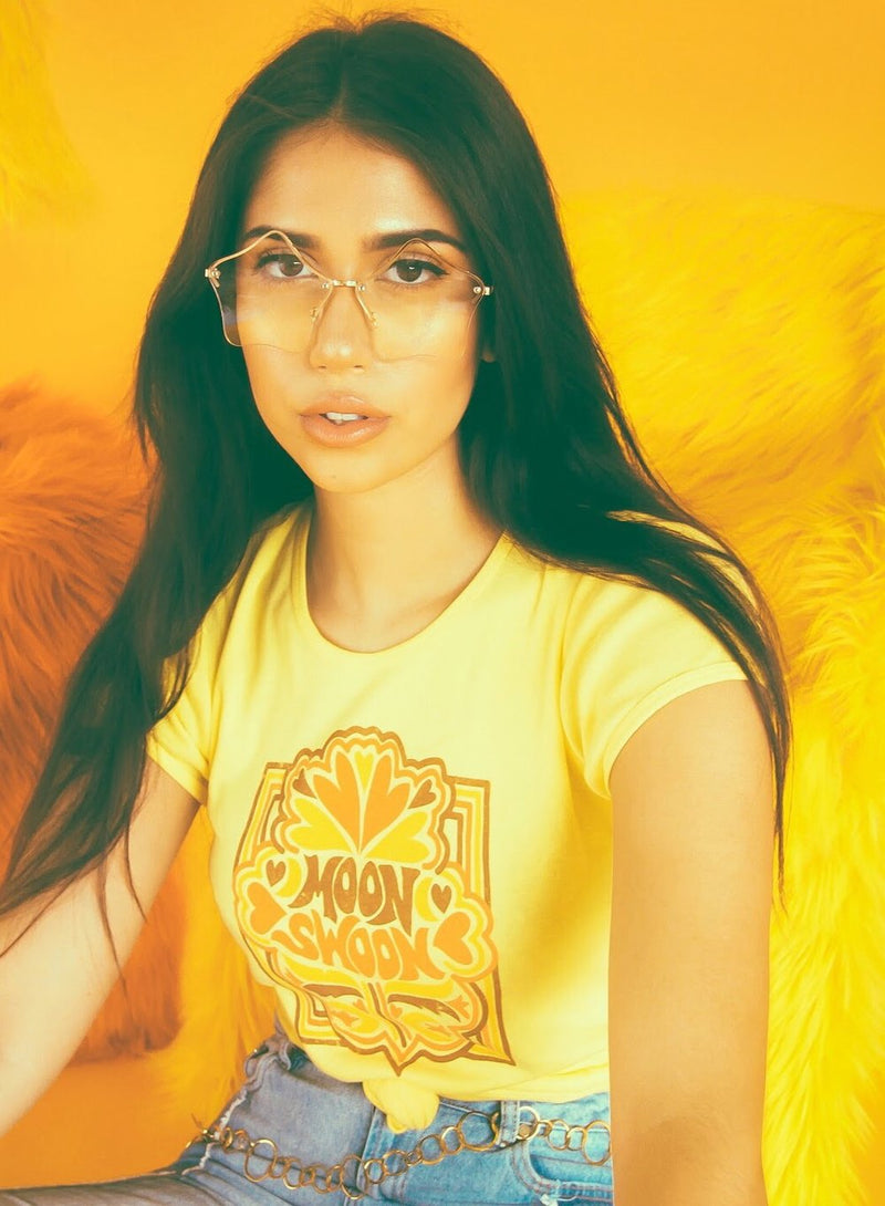 Brunette girl with glasses wearing yellow vintage inspired moon swoon tee by Top Knot Goods